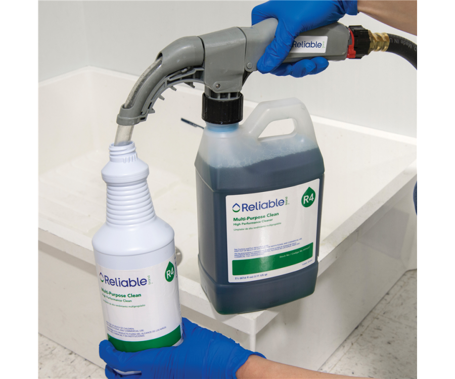 A person wearing blue gloves transferring liquid from a large container to a smaller bottle using a dispensing nozzle. Reliable Brand® Mint R4 High Performance Multi-Purpose Cleaner (2 l., 4 Bottles/CS)